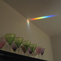 A prism integrated in a window across the room throws a rainbow when the sun is shining. (Champagne glasses by Ulla Forsell)